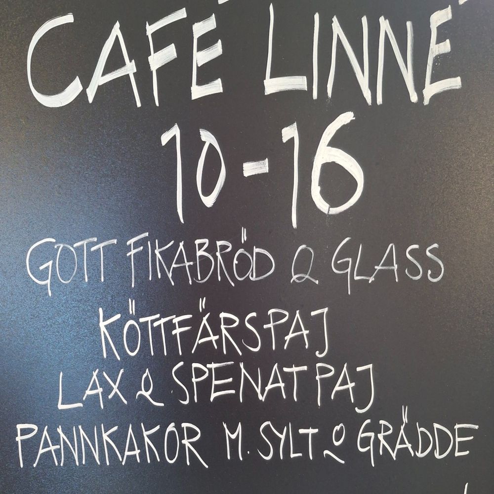 skylt som visar Café Linnés öppettider, 10-16.